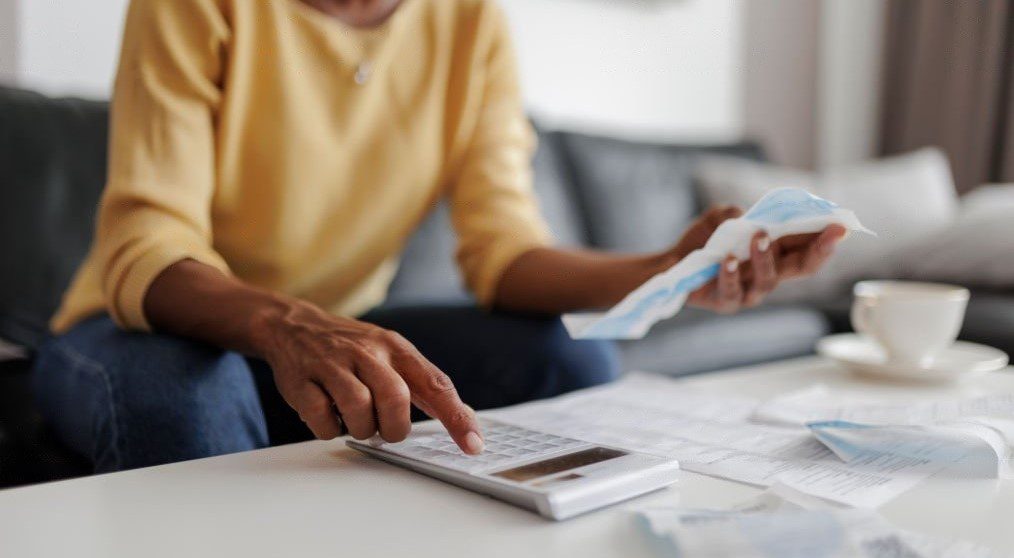 woman checking her energy bills at home. She has a worried expression thinking if she can afford to divorce her spouse