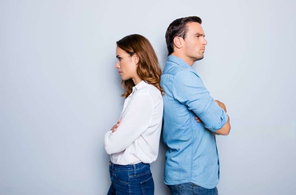 Couple stand with their backs against each other disagreeing on whether they should get a divorce